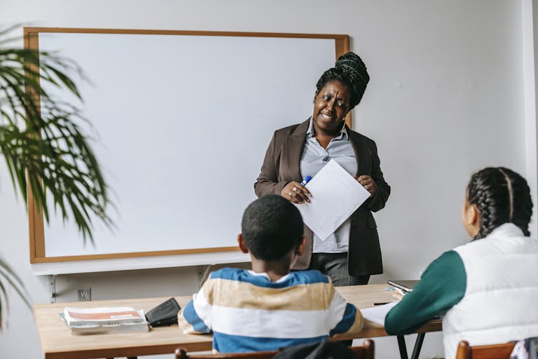 A teacher instructs diverse students in a classroom setting, fostering education and engagement.