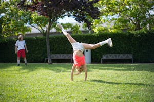 Two children playing in a sunny park, enjoying outdoor fun and activities.